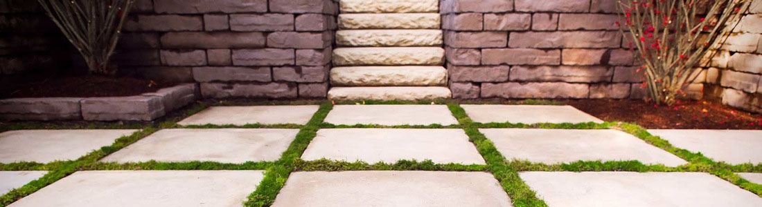 DIY How-To Projects: Stepping stone pathway with grass joints leading to stone steps and retaining walls in a landscaped backyard.